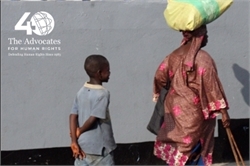 [ai] A woman carrying a large load on her head walks along a street, while a child follows closely behind with their hands clasped behind their back.